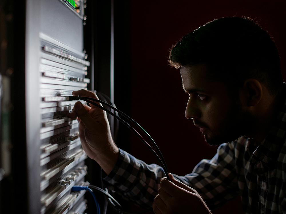 engineer plugging cables into router